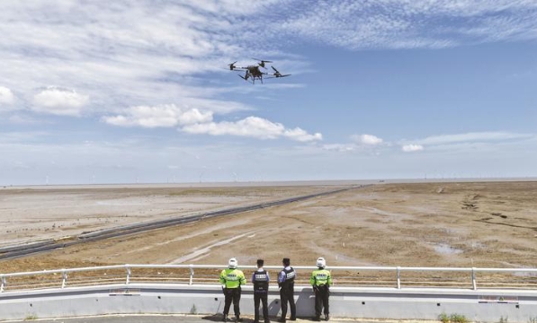 民警、輔警操控?zé)o人機(jī)在沿海灘涂巡防